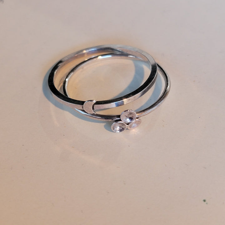 2 sterling silver bands, 1 with moon accent, one with dome accents