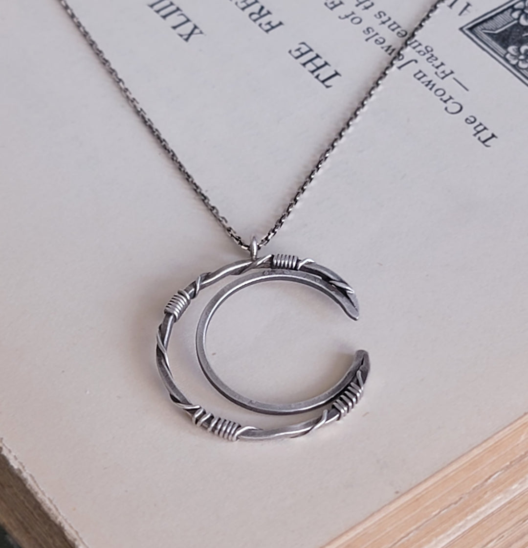 crescent moon pendant on book background