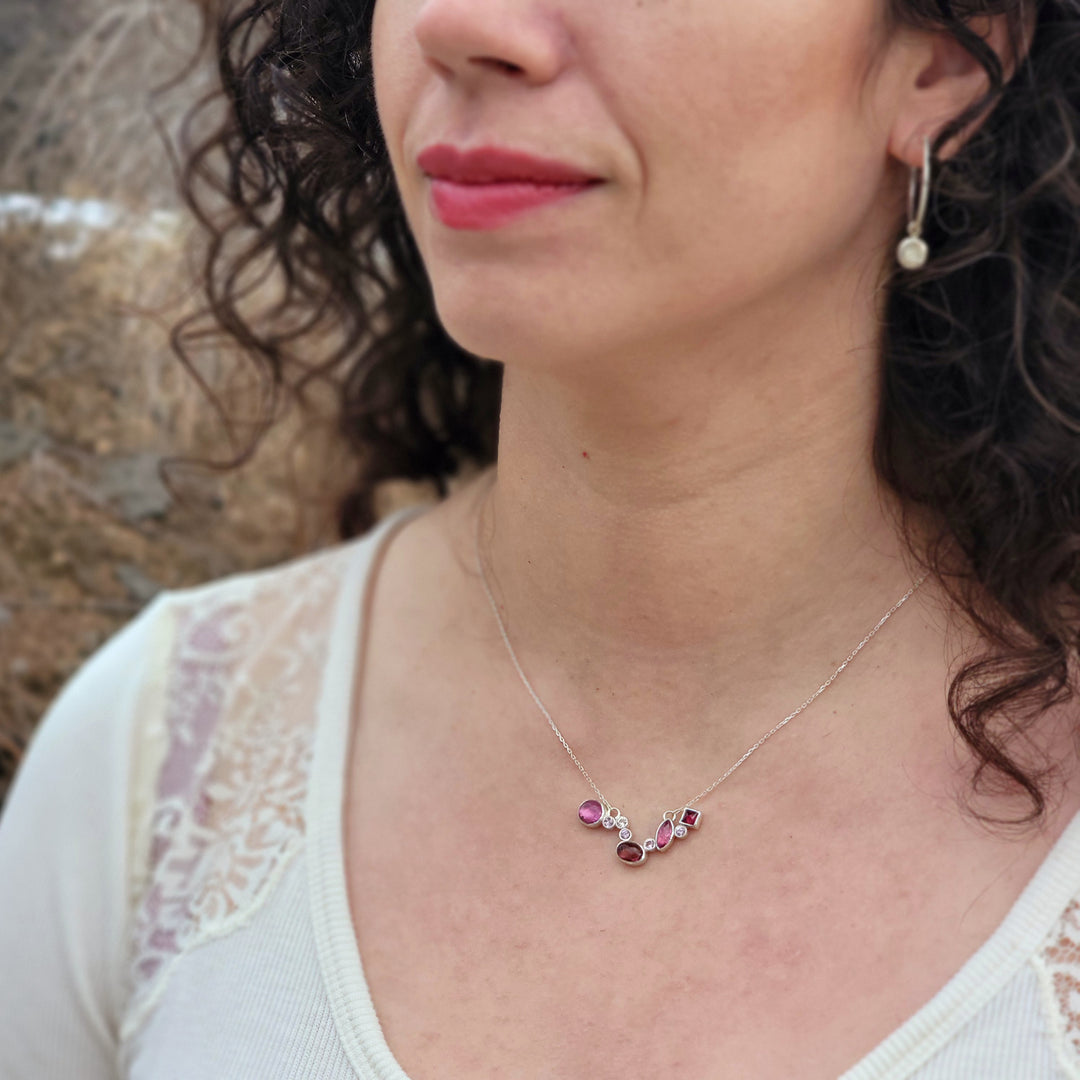 magenta and baby pink cluster necklace on model in front of wooded background